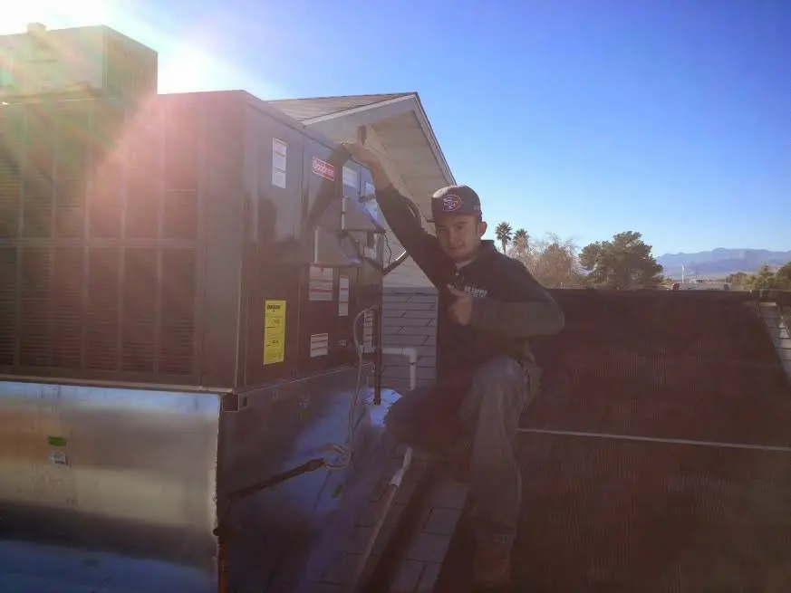 HVAC technician performing Heat Pump Repair on a rooftop unit in Colby